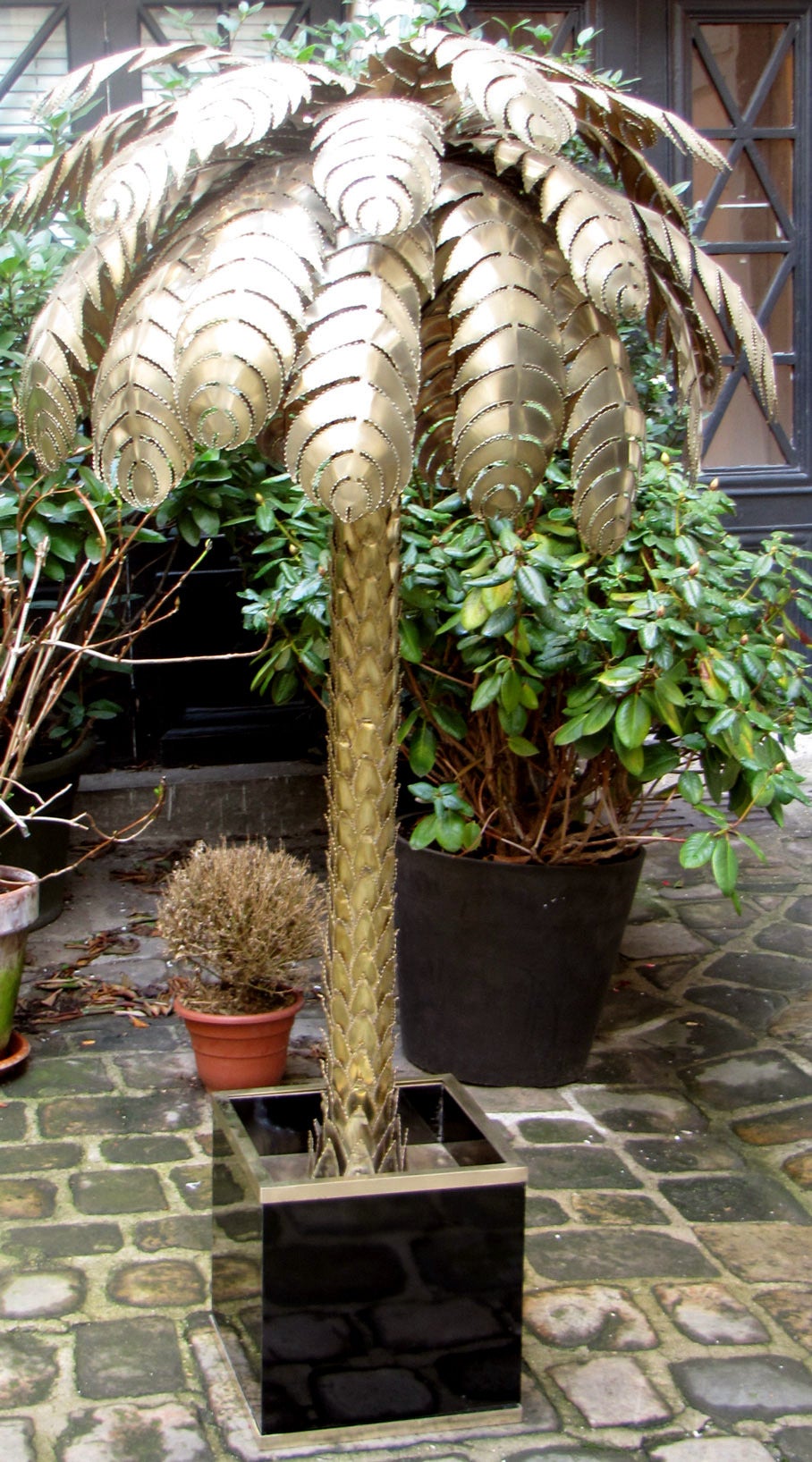 Pair of large iconic palm tree design floor lamps by Techoueyres,
 circa 1970. Palm tree is in worked brass, in a planter made in gloss black laminate and brass, bordered with a polished brass ledge. Four lights each.

Dimensions of each planter