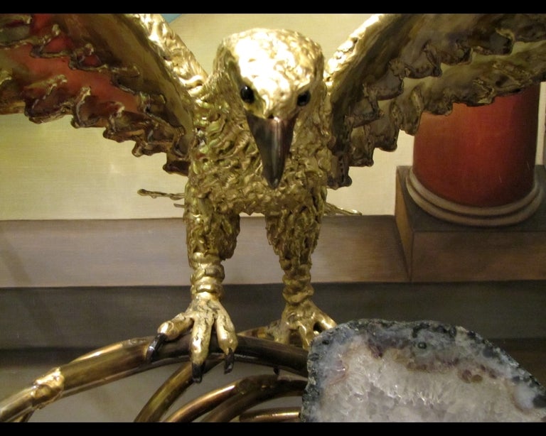 Unique light sculpture in brass worked. The eagle is perched on a liana, enchasing a thick slice of crystalline amethyst. Light is hidden by a mask of brass, behind the amethyst. Unique piece. Signed.