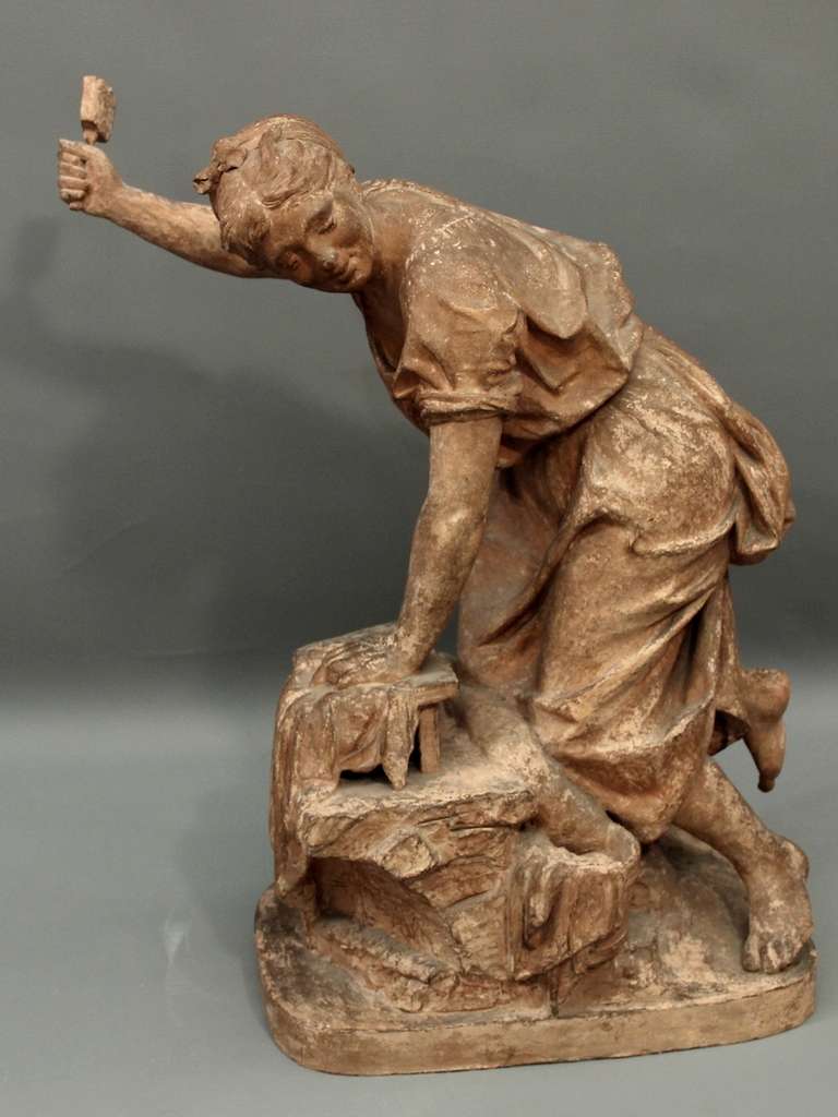 Terracotta originale che rappresenta una giovane donna inginocchiata su una pietra che lava i panni. Firmato (?) e datato 1870.