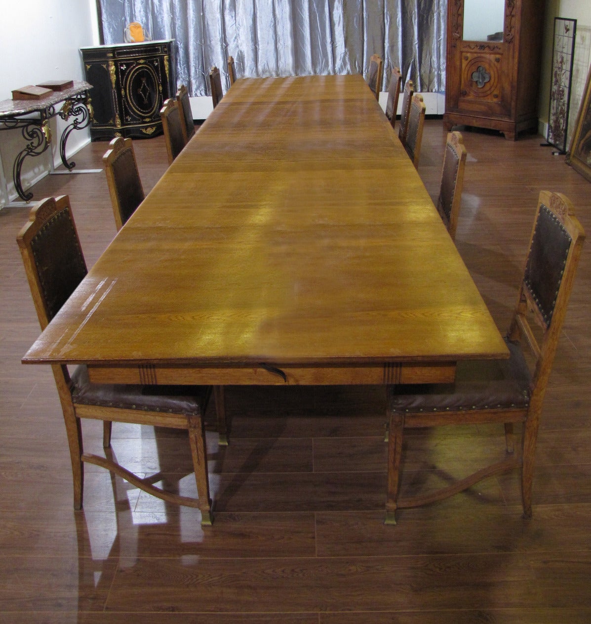 Interesting dining room set of a table with four original extensions and 12 chairs, in carved oak with bronze hooves.

Dimensions of the table without extensions are:
Length: 188 cm.
Height: 75 cm.
Depth: 115 cm.