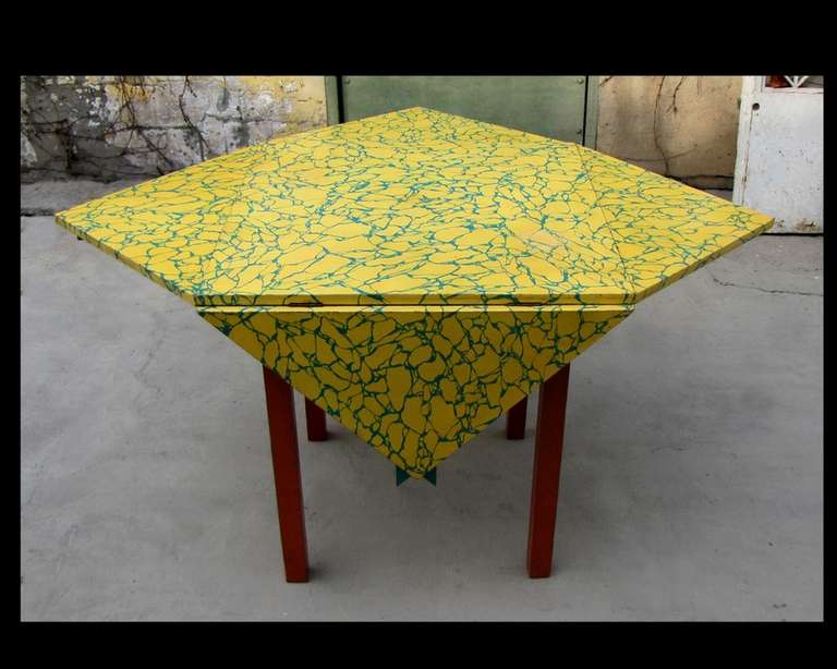 Very funny table with four drop leaves in painted wood like fanciful faux marble in yellow and green. Legs painted in red color. 
70cm X 70 cm closed
110cm X 110 cm open