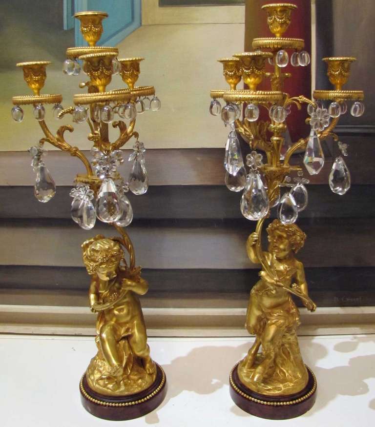 Two girandoles in gilded bronze with crystal pendants on a round 
