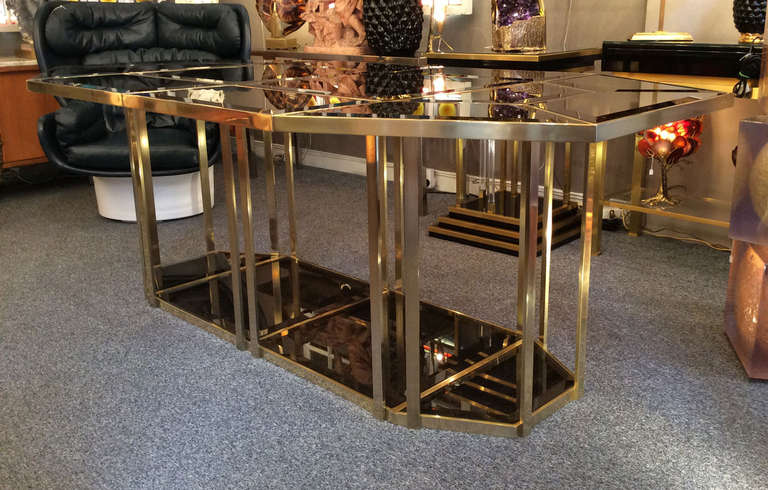 Large 1970's dining table in four parts, all made of brass with pieces of beveled smoked glass included. It's possible to make a smaller table with two or three parts.
