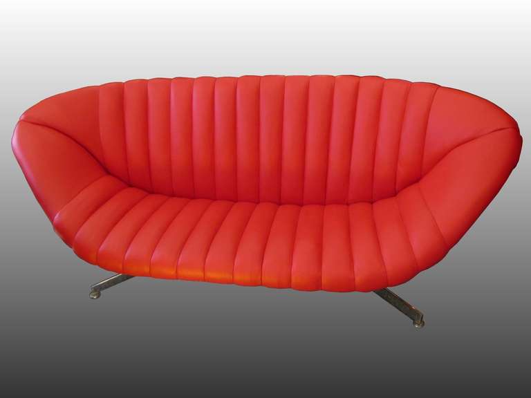 Insolite et magnifique canapé de 1950, base en métal chromé. Recouvert de cuir rouge dans un ouvrage matelassé.