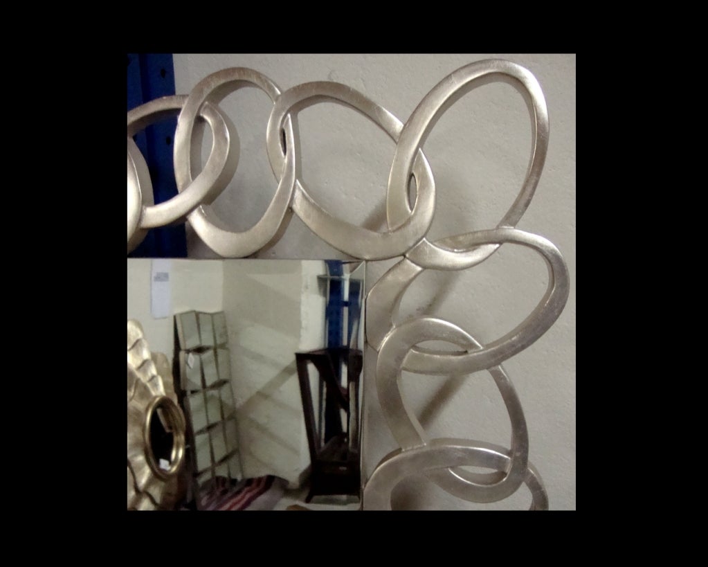 Miroir contemporain. Cadre en bois argenté et sculpté. Miroir transparent.