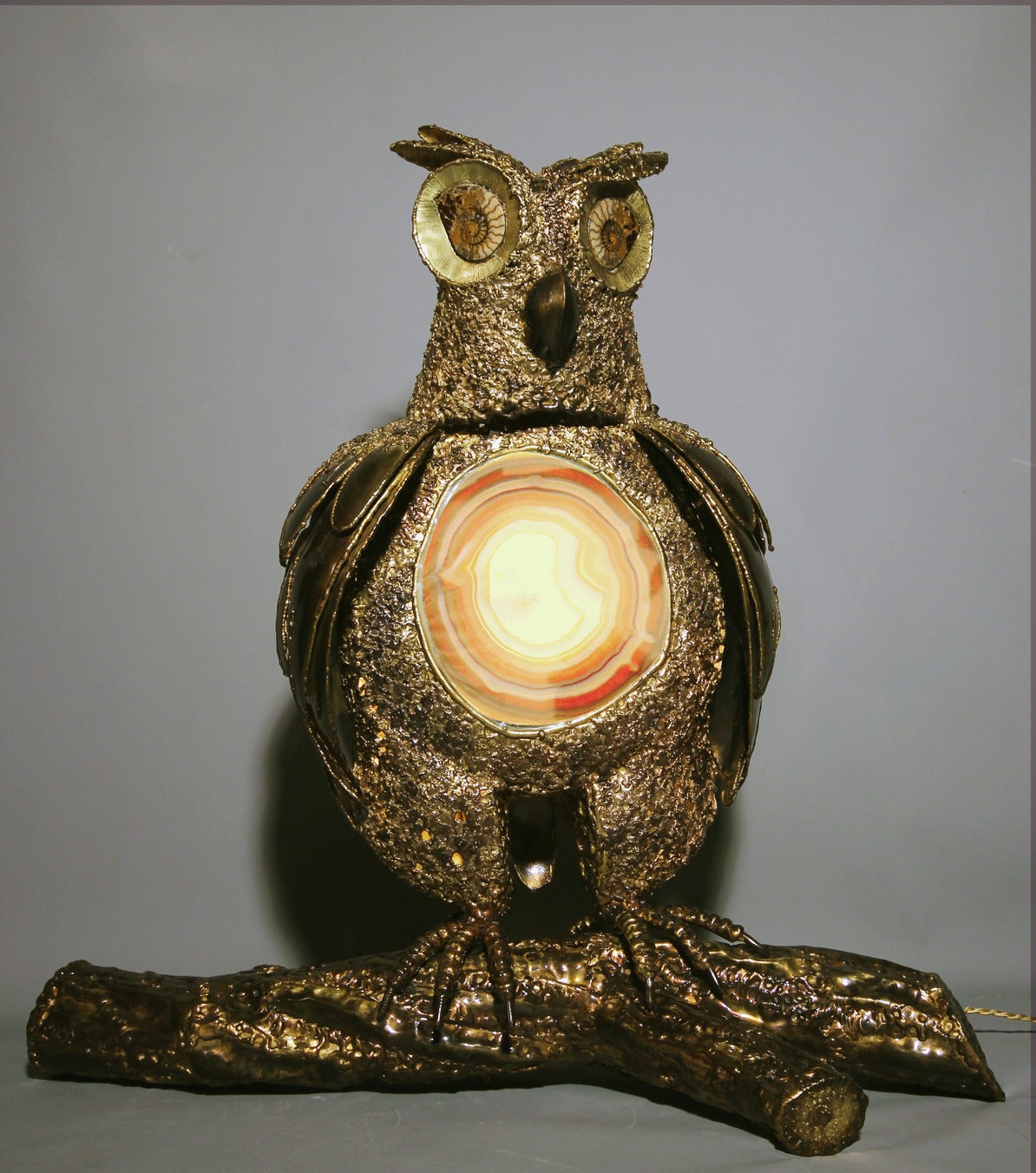 Spectacular luminous sculpture by Richard Faure in worked brass.
The abdomen is made from a slice of agate concealing the lighting, the eyes are two fossil ammonites. Unique piece. Signed.