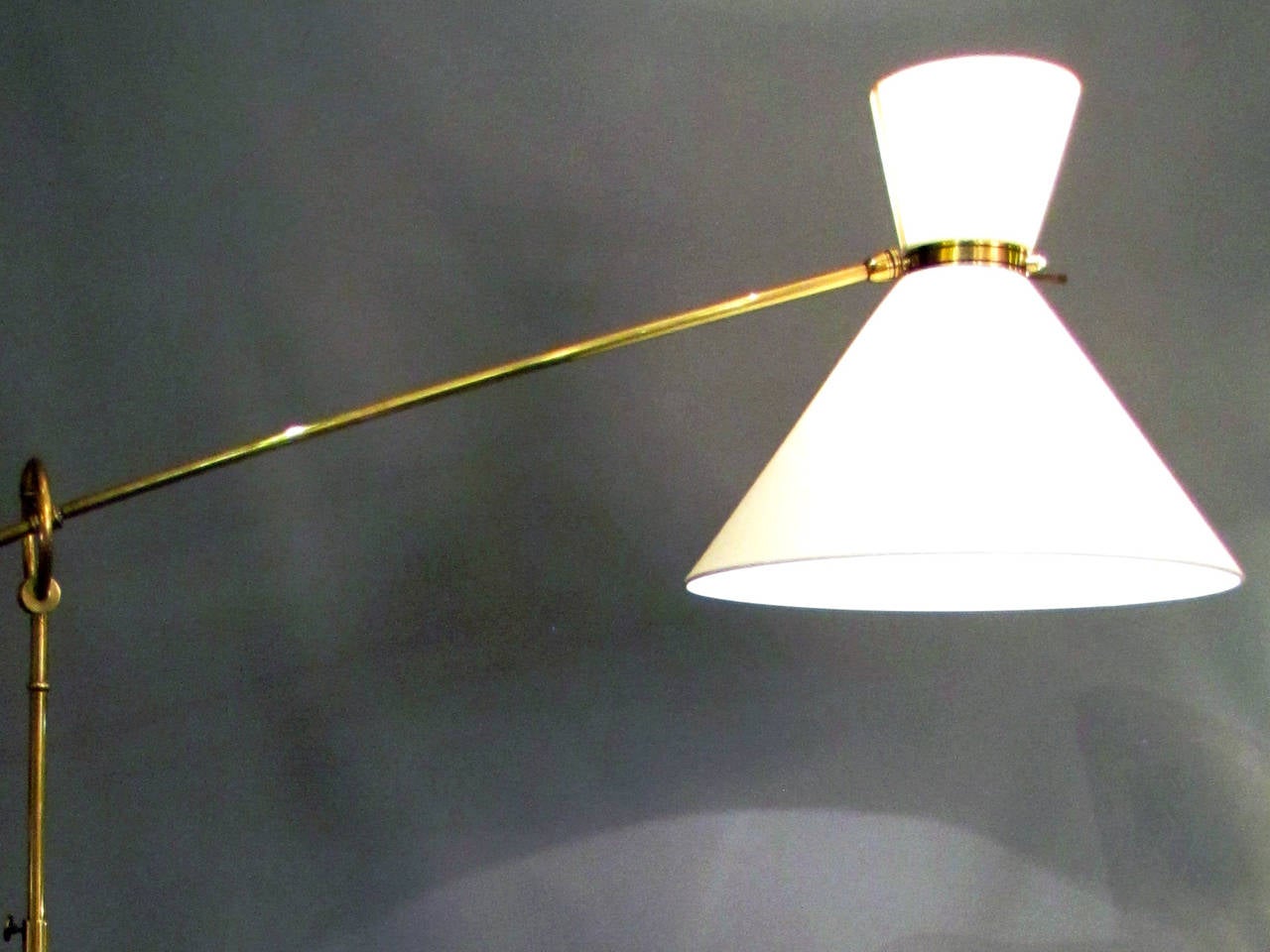 Floor lamp with swivel arm in polished brass.
Circular base where stands one adjustable rod receiving a swivel arm. Orientable conical lampshades in off-white fabric.

Heigth of the rod: 4 ft. 9.09 in to 6 ft. 2.8 in.
Length of the arm: 3 ft.