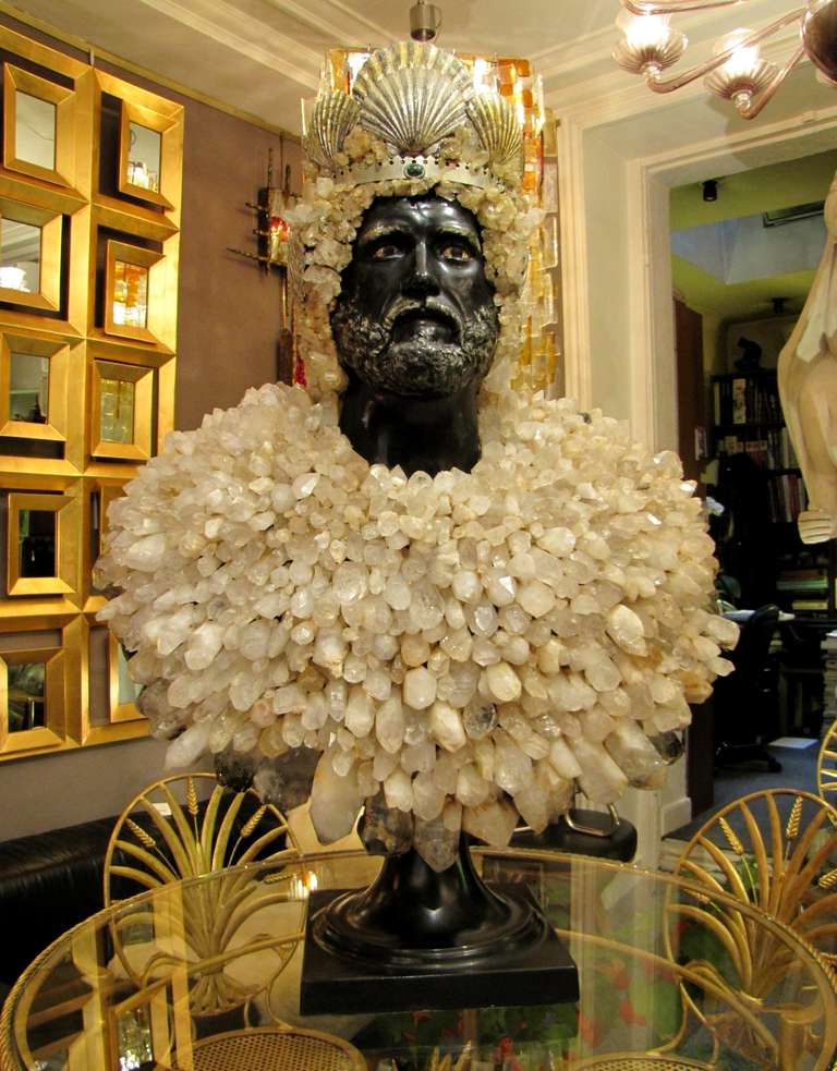 Important bust of Neptune in black and painted resin, with a multitude of rock crystals completely covering it chest.
Neptune haired rock crystals and wears a headdress Saint Jacques coquilles and a silver metal crown, decorated with malachite