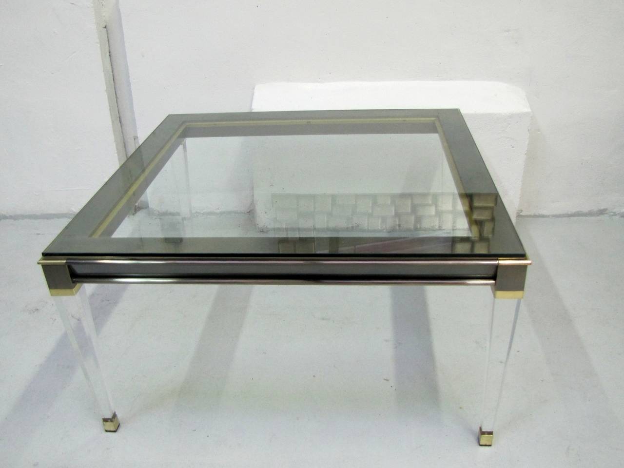 Grande table basse en verre, acier, laiton doré et Lucite. Qualité supérieure et état parfait.