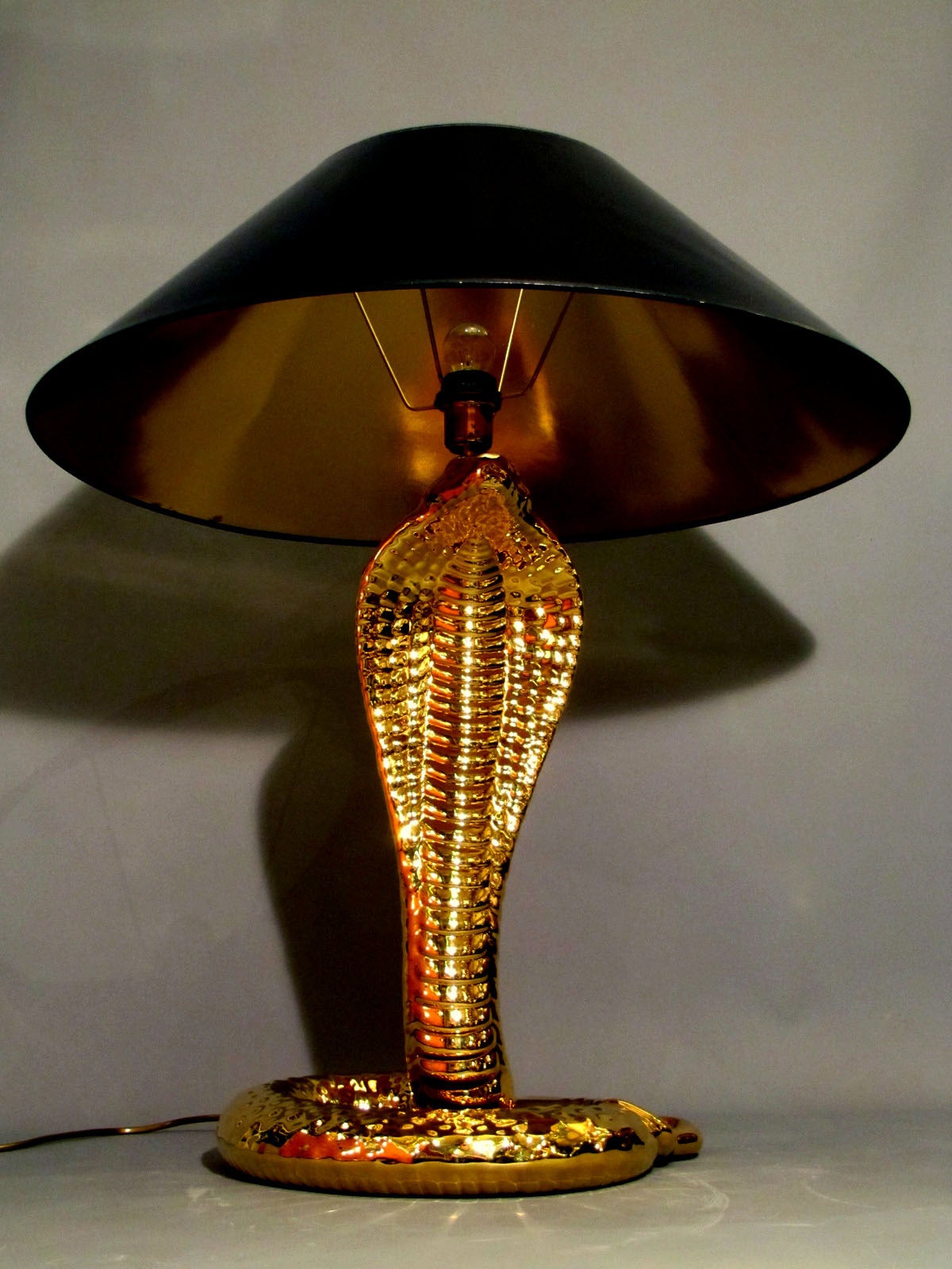 Unique gold-glazed ceramic table lamp in the shape of a cobra. A fine work signed by Tommaso Barbi, 1970 period. In absolutely perfect condition with original lampshade.
Height without lampshade is 63 cm.