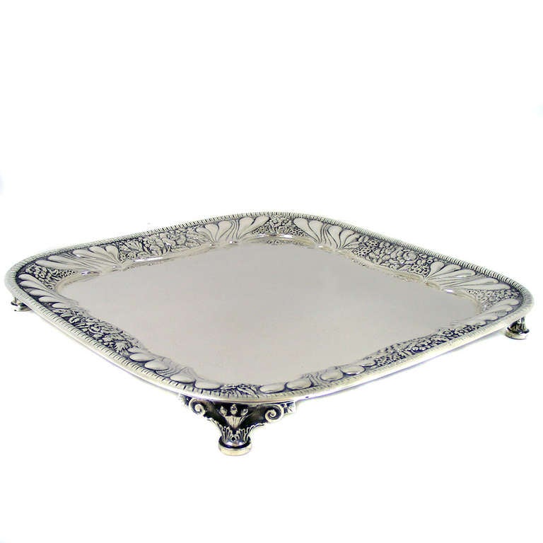 A sublime example of 19th century New York silver, this Tiffany & Co. salver features a sophisticated repousse rim and unusually decorative applied feet. The square form is rare and especially useful. Excellent condition. 
 
Remarks from Lawrence