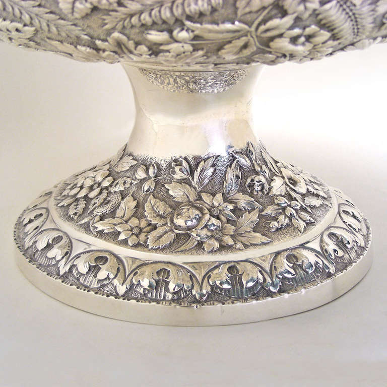 Circa 1880-90s, this centerpiece was made in sterling by Kirk and Sons and retailed by Hennegan Bates & Co. of Baltimore.  An imposing example of Samuel Kirk's Repousse pattern, this centerpiece is perfect for an ornate décor or to spot a modernist