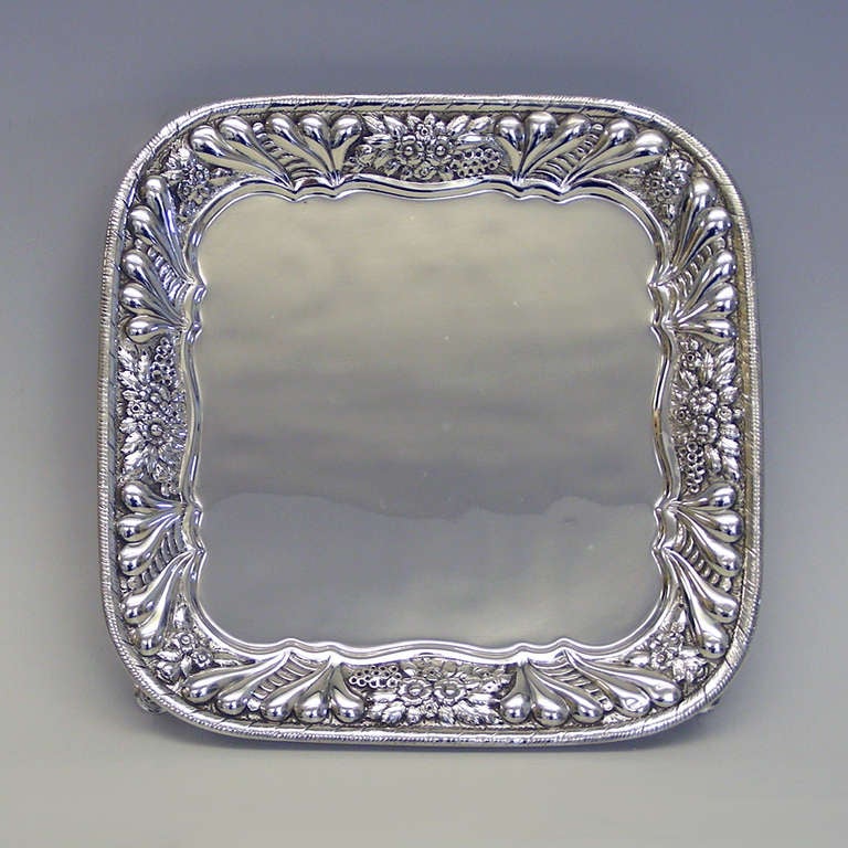 Perfect for use as a card tray or a stand for Champagne or a coffee pot, this splendid example of late 19th century Tiffany silver is hand chased and features wonderful revivalist feet. 

HALLMARKS:  Tiffany & Co., Sterling Silver, 5768,  M and