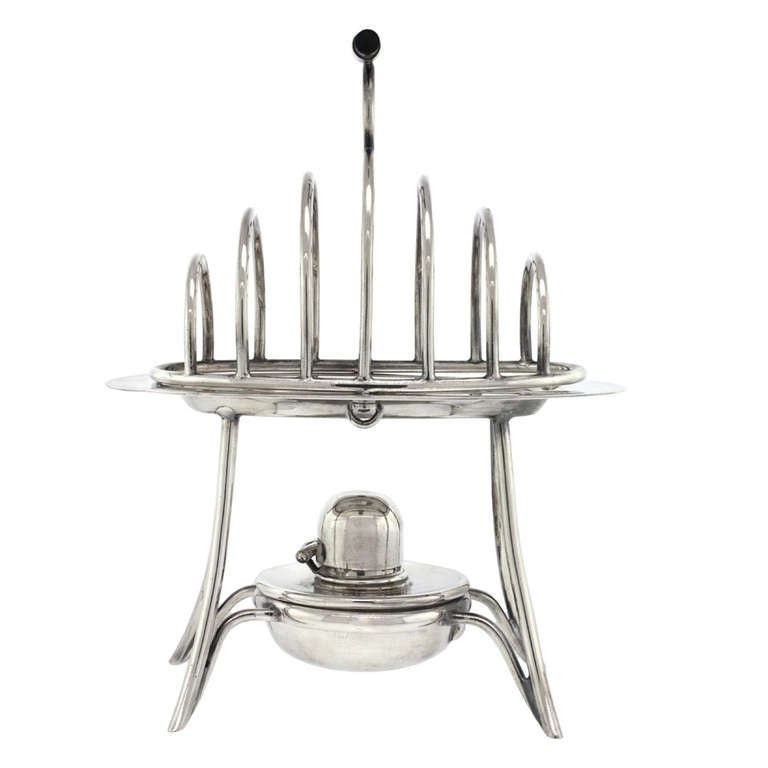 Sleek of form and perfectly functional, this silver-plate toast rack by Asprey of London has the unique feature of a burner to keep the toast warm. Excellent condition.

HALLMARKS:  A&Co, Asprey, London and model number 20639

STOCK NUMBER: 