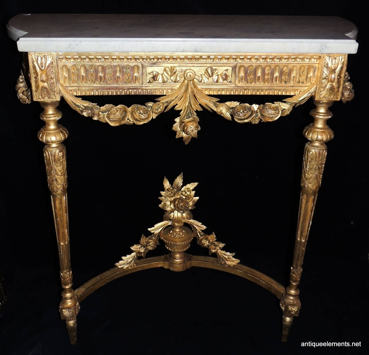 Pair of beautifully carved gilt wood consoles with shaped white marble with very light gray throughout. The carved center is richly detailed with large floral atop an
urn and floral draping to either side.  Throughout all 4 legs the floral and