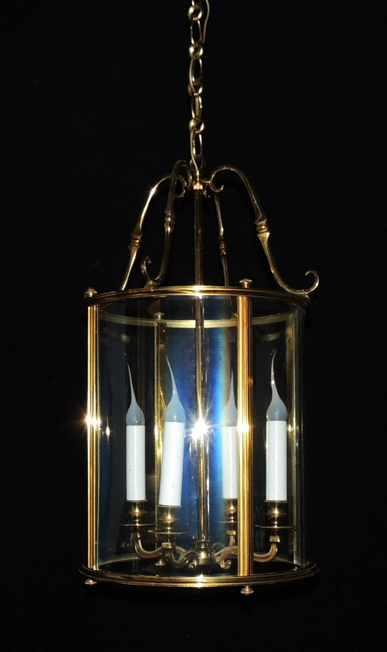Elegant pair of bronze lanterns with 4 lights and beautiful circular crystal enclosure. Scroll bronze detail at the top, simple lines along the bronze sides and scroll and etched bronze arms holding the 4 candelabra lights. 

Perfect over a
