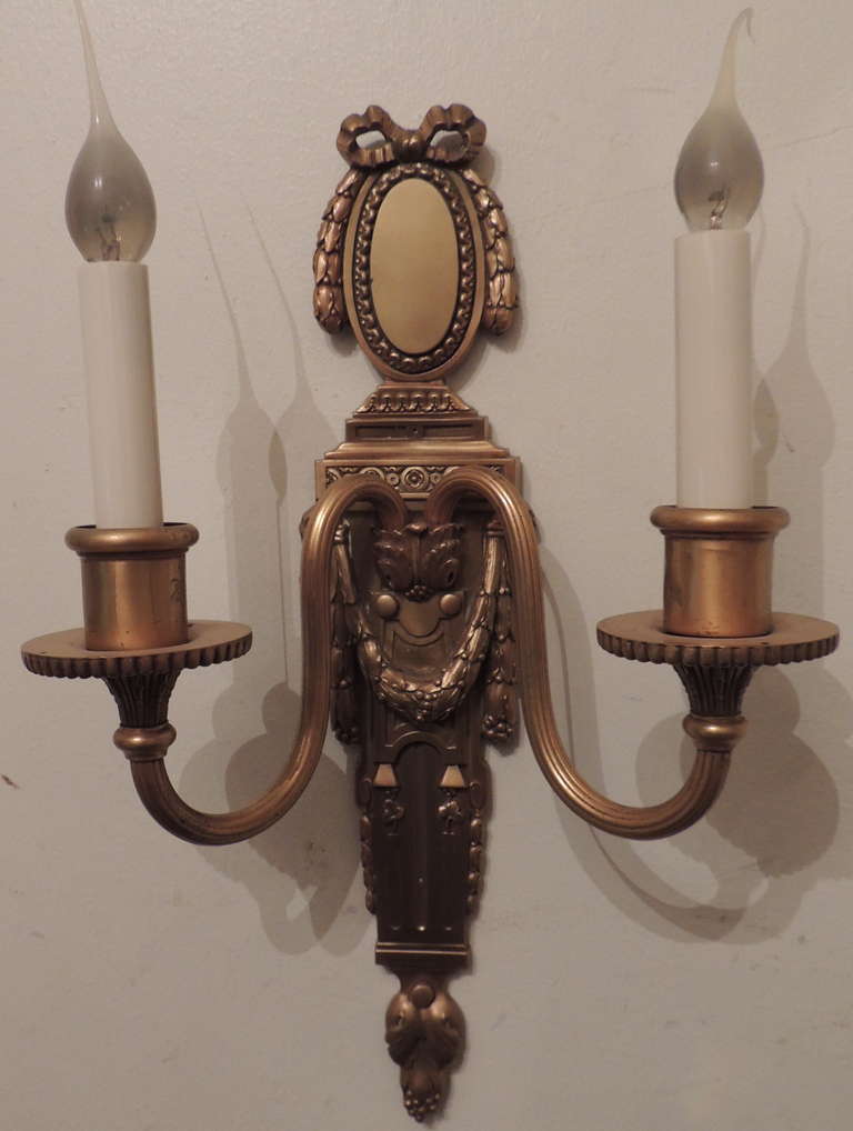 A fine pair gilt bronze neoclassical bow top two-arm
Wall Sconces, By E.F. Caldwell.