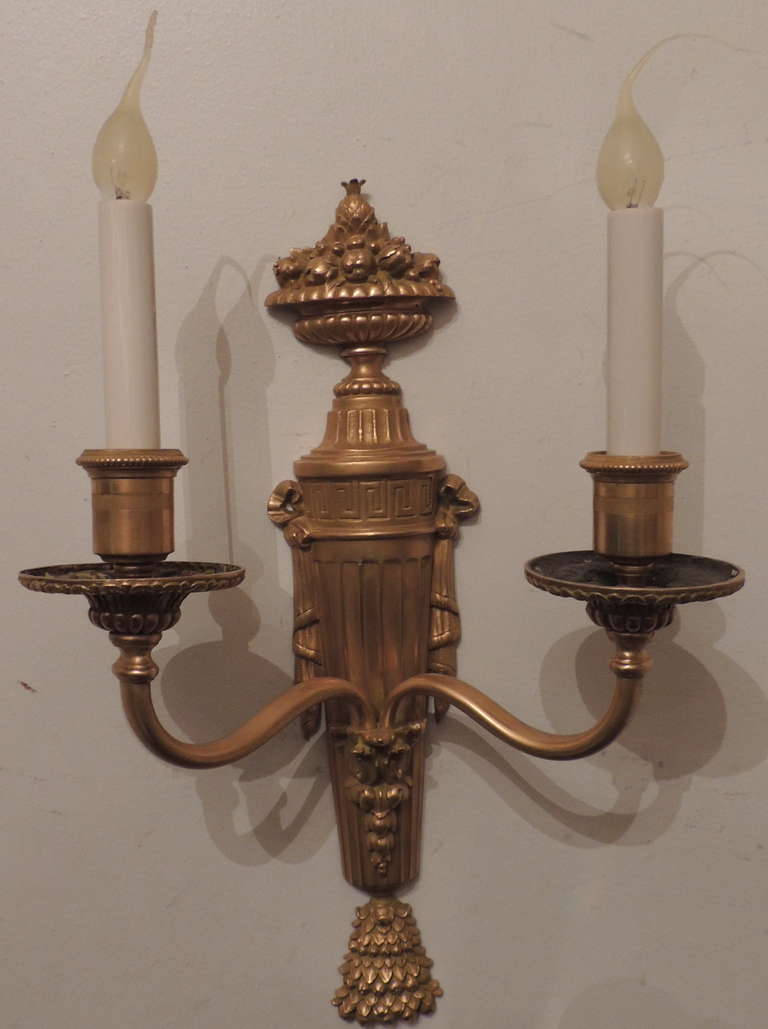 A fine pair of Doré bronze neoclassical
Two arm wall sconces with fruit basket on top
by E. F. Caldwell & Co.
