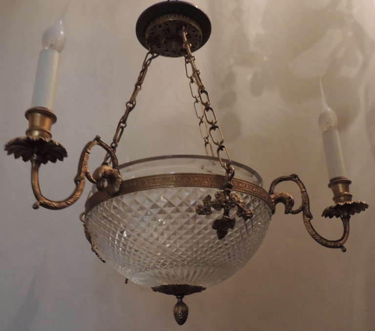 One of a pair available of this exceptional neoclassical doré bronze and cut crystal Empire three-light fixture with eagle heads surrounding the bowl in the Empire style. Price is per fixture.