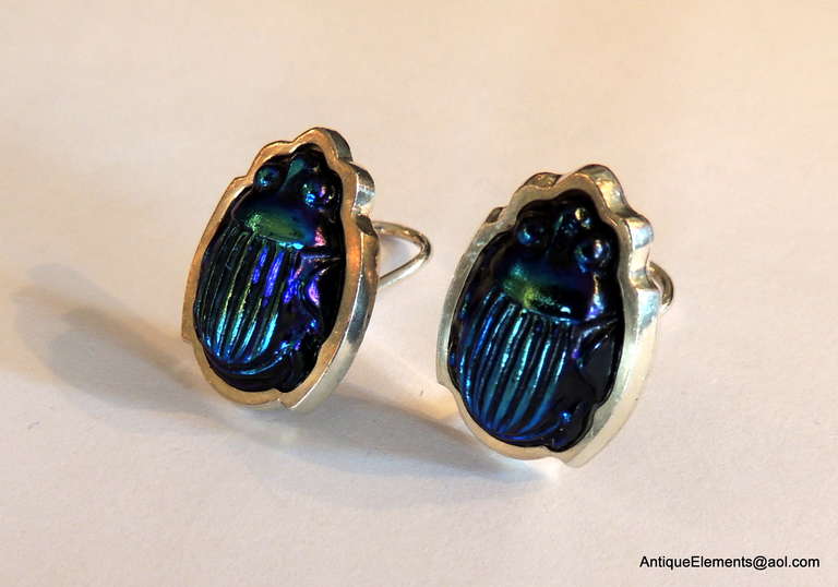 A Rare And Wonderful Vintage Tiffany & Co. Favrile Glass & Sterling Silver Scarab Beetle Earrings. The Colors Are Rich Opalescent Purple and Blue.
The Earrings are Each Signed Tiffany & Co. Sterling. Each Earring has A French Back in Very Good