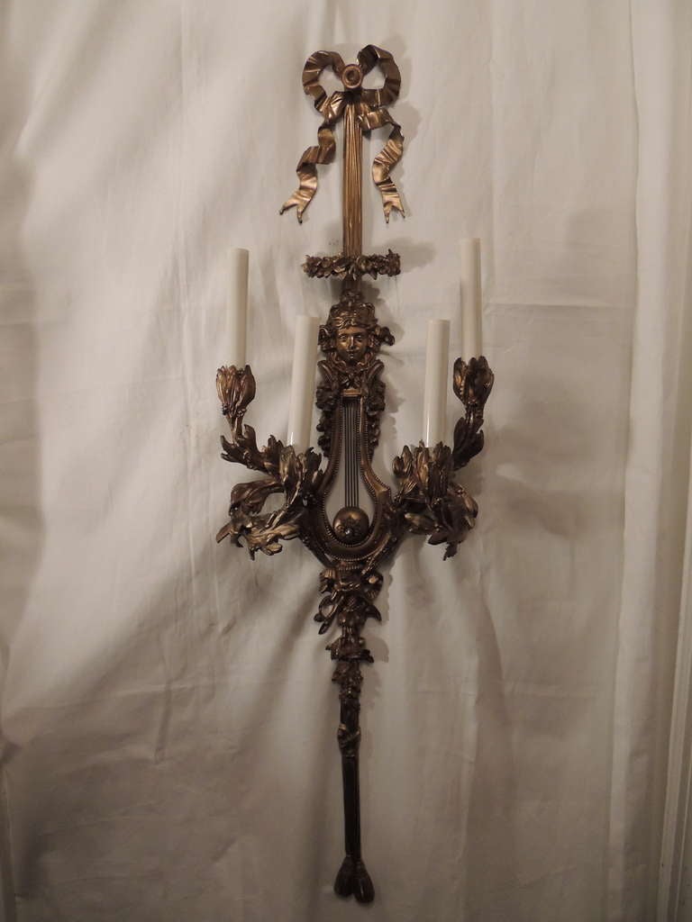 A palatial pair of French doré bronze four-light bow top and tassle wall sconces, newly wired.
