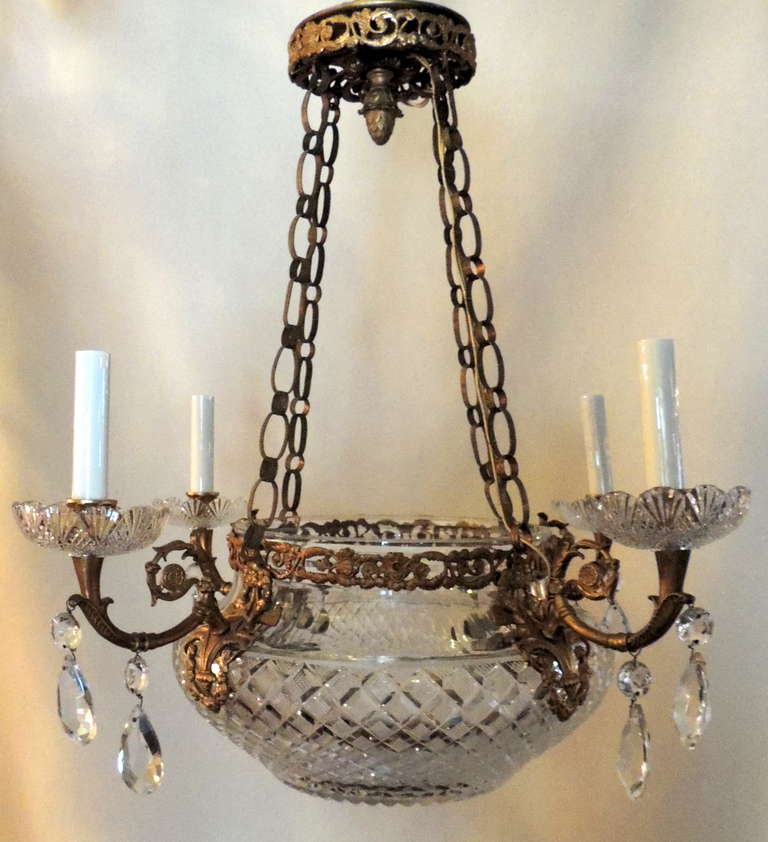 Exceptional French doré bronze and cut crystal empire four-light chandelier. With four masks surrounding the bowl and from which the arms derive.
Each arm ending with a fine cut crystal bobèches from which crystals drape. Internally there are four
