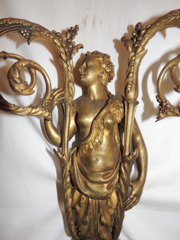 A pair of very fine 19th century French empire doré bronze figural two-arm sconces. The left facing figure is of a woman, and countering her is the right facing man.

Provenance to this pair: Purchased From Sotheby's New York.