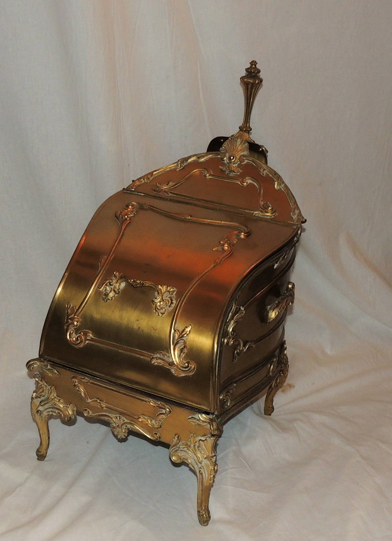 Wonderful scroll details decorate this beautiful bronze coal box with original matching decorated shovel.  From the scroll entwined legs, the hatch opens to reveal the original removable insert. Closed, the box has a elegant appearance, perfect as a