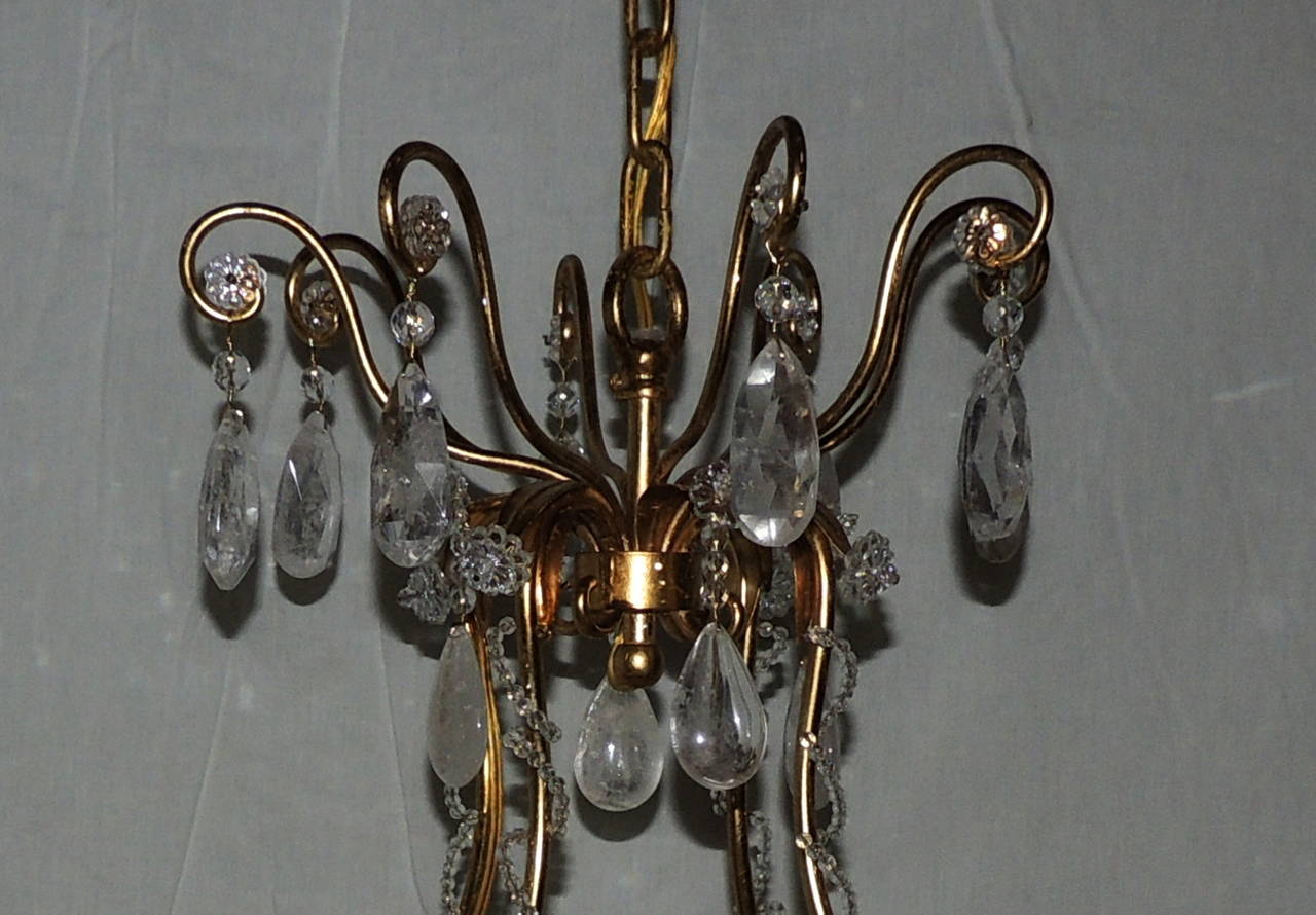 Fabulous Bagues style gilt and rock crystal chandelier with eight graceful arms along with gilt leaves accenting the centre finial. Throughout the chandelier there are crystal beading details along with accents of crystal flowers. The mix of prism,