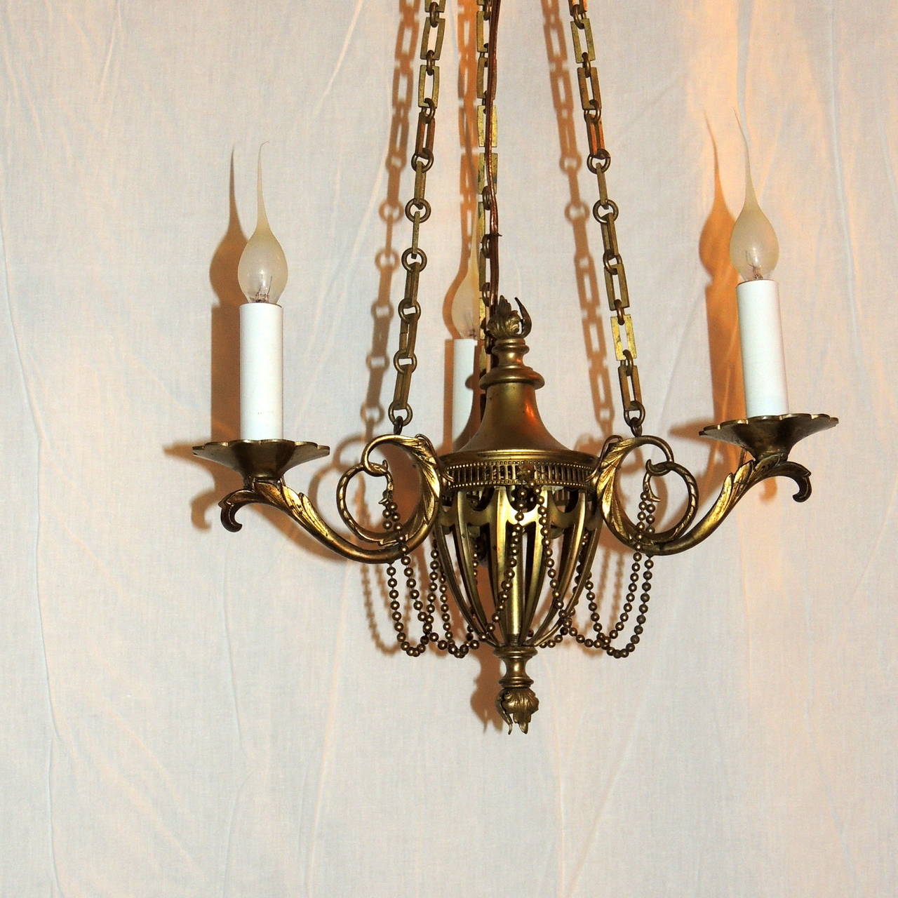 Gilt Neoclassical Three-Arm French Bronze Swag and Scroll-Arm Chandelier For Sale