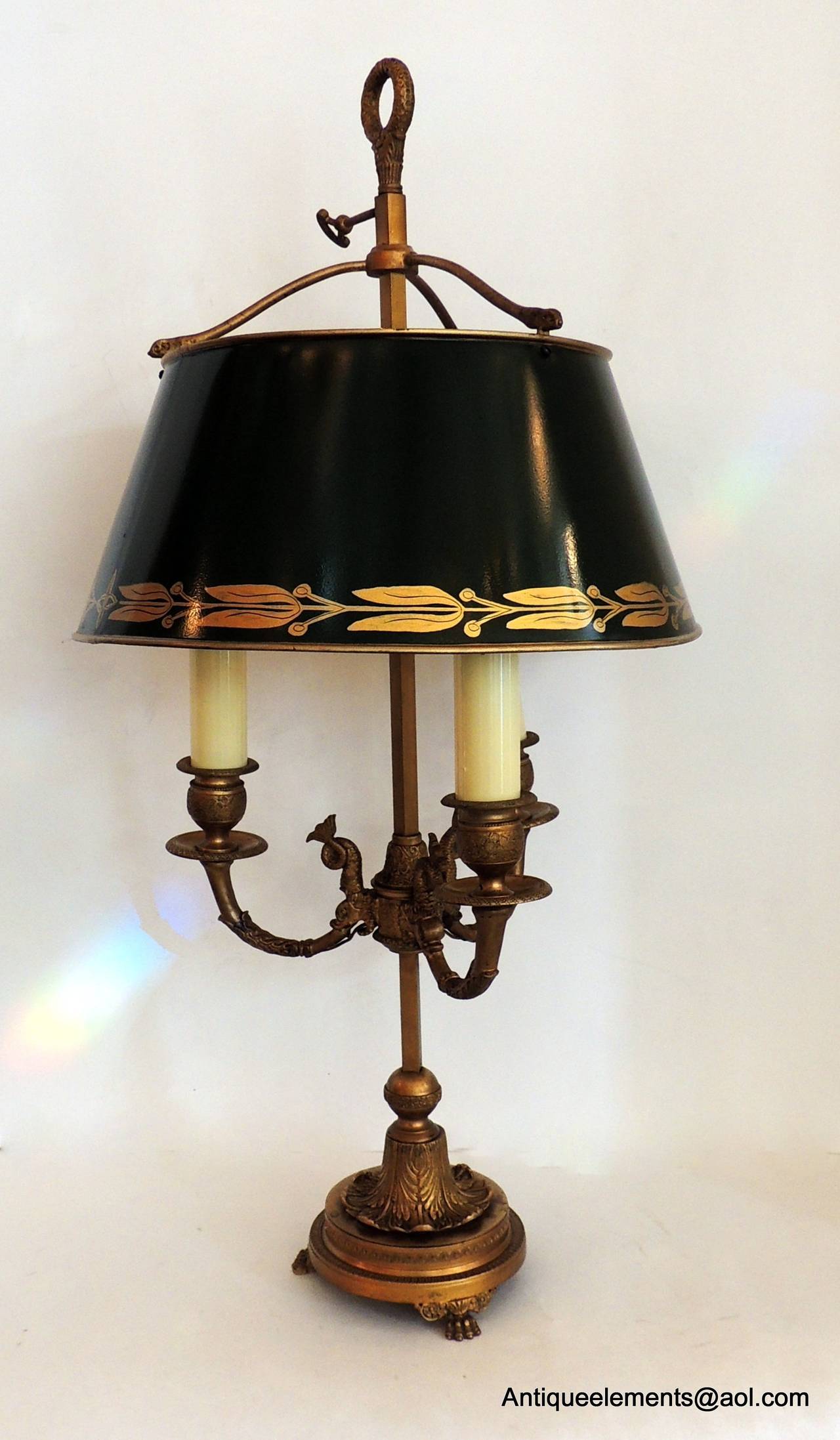 This vintage French pair of hand-painted green three-light Bouillotte lamps
are in wonderful condition. The incredible gilt bronze detailed engraving on the base carries up to the sea creatures whose tails wraparound the candle arms. The engraving