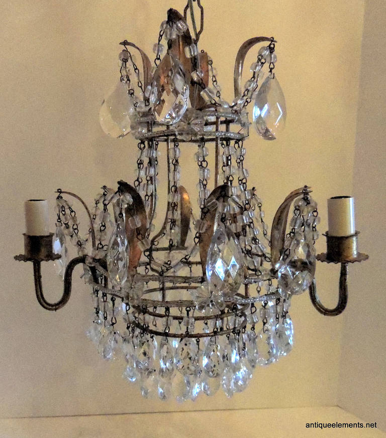 Perfect for the reading nook, dressing area or small space that is in need of some attention; this petite circular chandelier is for you. Two tiers of bottom crystal prisms capture the light from this 3 arm chandelier. The crystal starts at the top,