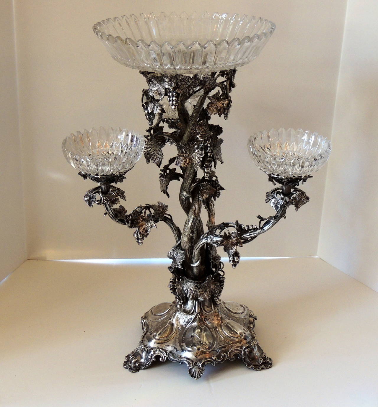 This wonderful silver plated epergne is shaped like branches of a tree with limbs holding the original crystal bowls. The main top cut crystal bowl is a generous 10