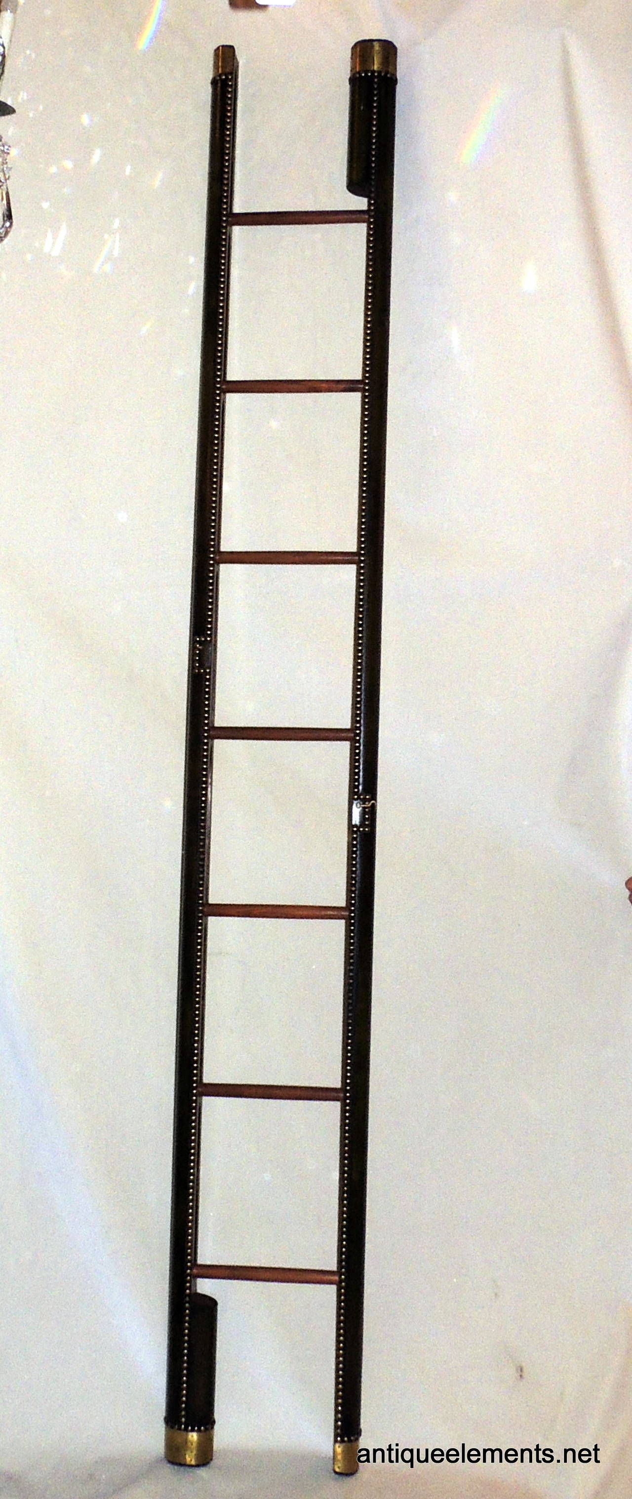 This elegant vintage English folding ladder is made of beautiful mahogany
wood and encased in a rich green leather that is trimmed with brass nailheads, cups and latch which allows it to be stored in a narrow space.

Measure: Closed 10" H x