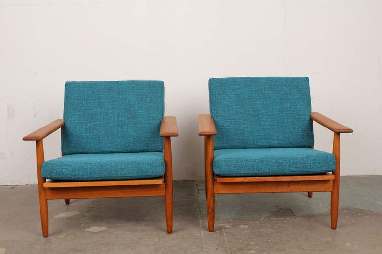 A pair of teak mid-century modern lounge chairs.  Oil finished teak frames with newly upholstered cushions.