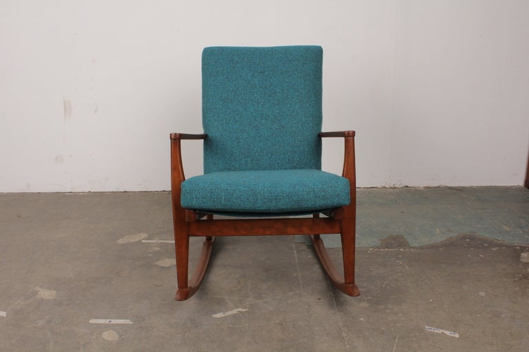 English mid century modern rocking chair with wood frame, upholstered back and spring seat from Parker Knoll.