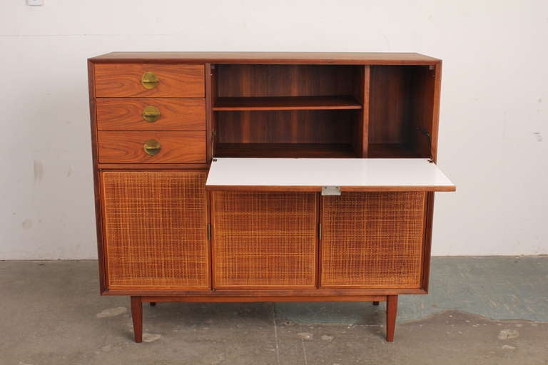 Walnut and cane cabinet/credenza/bar designed by Jack Cartwright for Founders Furniture, a subsidiary of Knoll. Circa 1960s.