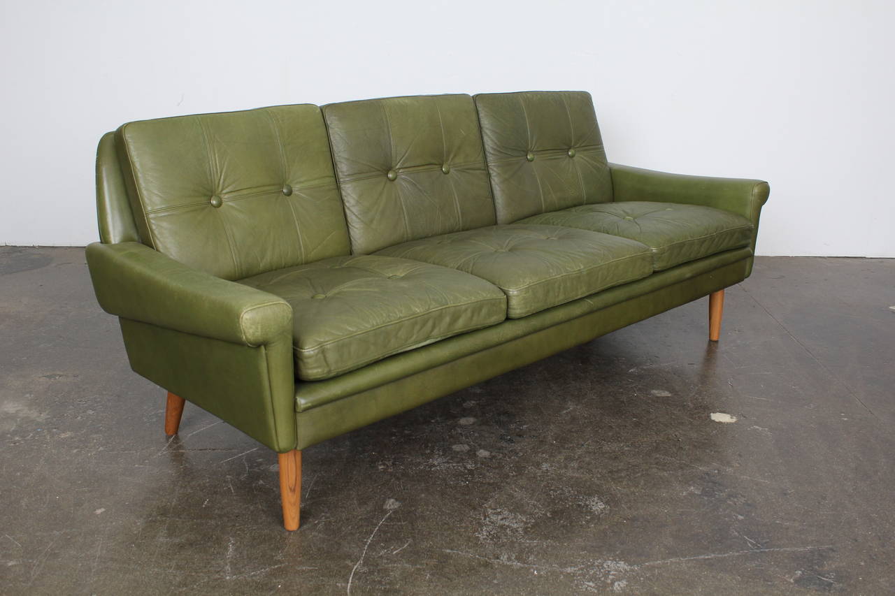 Vintage three-seat sofa by Skippers Mobler in original green leather upholstery. Subtly flared arms along with the tufted cushions give this piece a traditionalist, almost rustic feel. Matching loveseat sold separately.