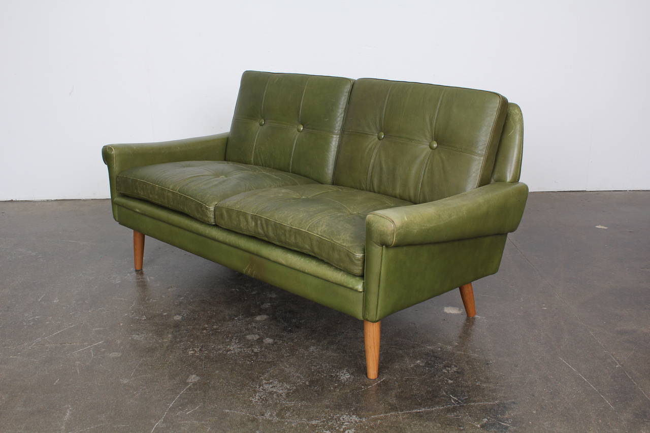 Vintage loveseat by Skippers Mobler in original green leather upholstery.  Subtly flared arms along with the tufted cushions give this piece a traditionalist, almost rustic feel. Matching sofa sold separately.