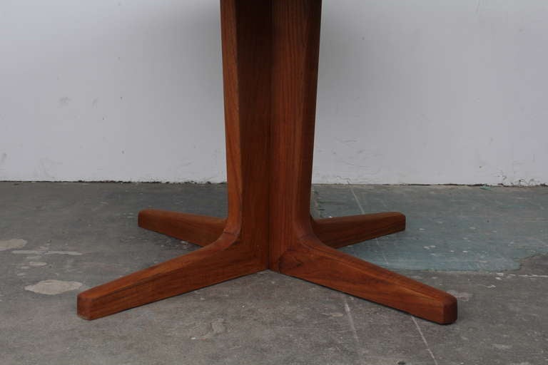 Danish mid century round teak dining table with a pedestal that separates to allow the table to extend into an oval.  This table has beautiful solid lines and will fit perfectly in any modern styled home.  The table has an oil finish.  The table