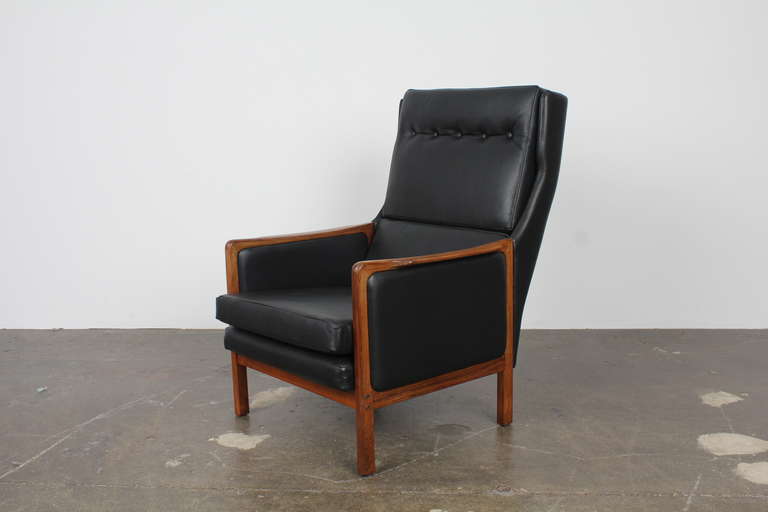Danish modern tall back lounge chair, newly upholstered in black leather with button tufted cushions and a beautiful rosewood frame.