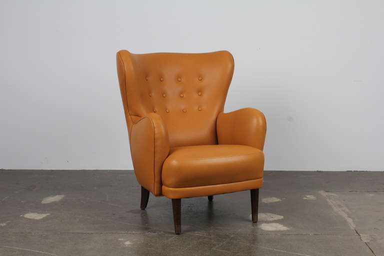 Elegant mid century modern lounge chair in a beautiful soft butterscotch brown leather with tight back and tight seat, button tufting. Danish, most likely 1940's to 1950's in the manner of Fritz Henningsen.