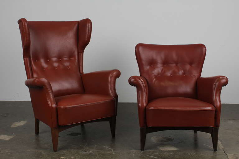 Danish Mid-Century Modern brick red leather his and hers lounge chairs, with button tufting and tight back/seat design.  Very similar to, if not by Fritz Henningsen (not positive though, so don't want to say it is).  Excellent condition with