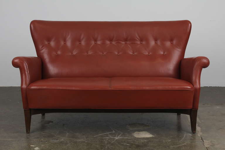 Danish Mid-Century Modern brick red leather sofa, with button tufting and tight back/seat design. Very similar to, if not by Fritz Henningsen (not positive though, so don't want to say it is). Excellent condition with wonderful patina. Has a