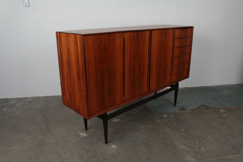 Danish mid century modern 3 door, 6 drawer rosewood credenza on floating style tapering legs.  Interior shelving storage in each of the 3 compartments.  Piece has been newly refinished in lacquer.