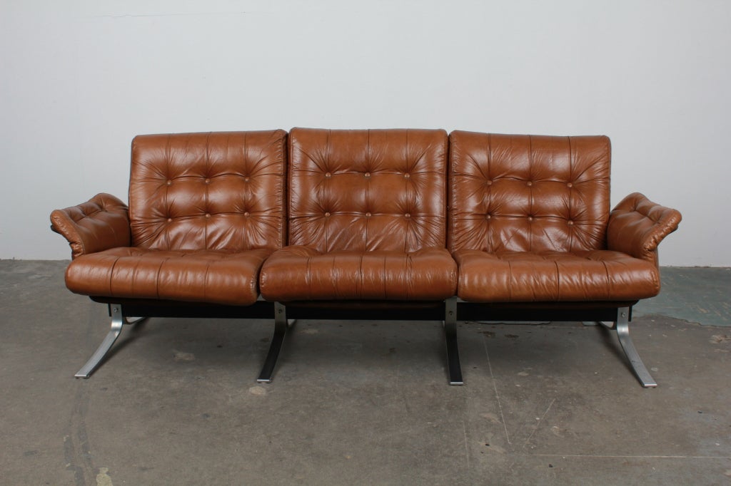 Danish mid century modern 3 seat tufted leather and metal framed sofa by Ebbe Gehl & Søren Nissen. Model Atlantis produced by Jeki Møbler. Recently reupholstered in leather that has seen some usage.