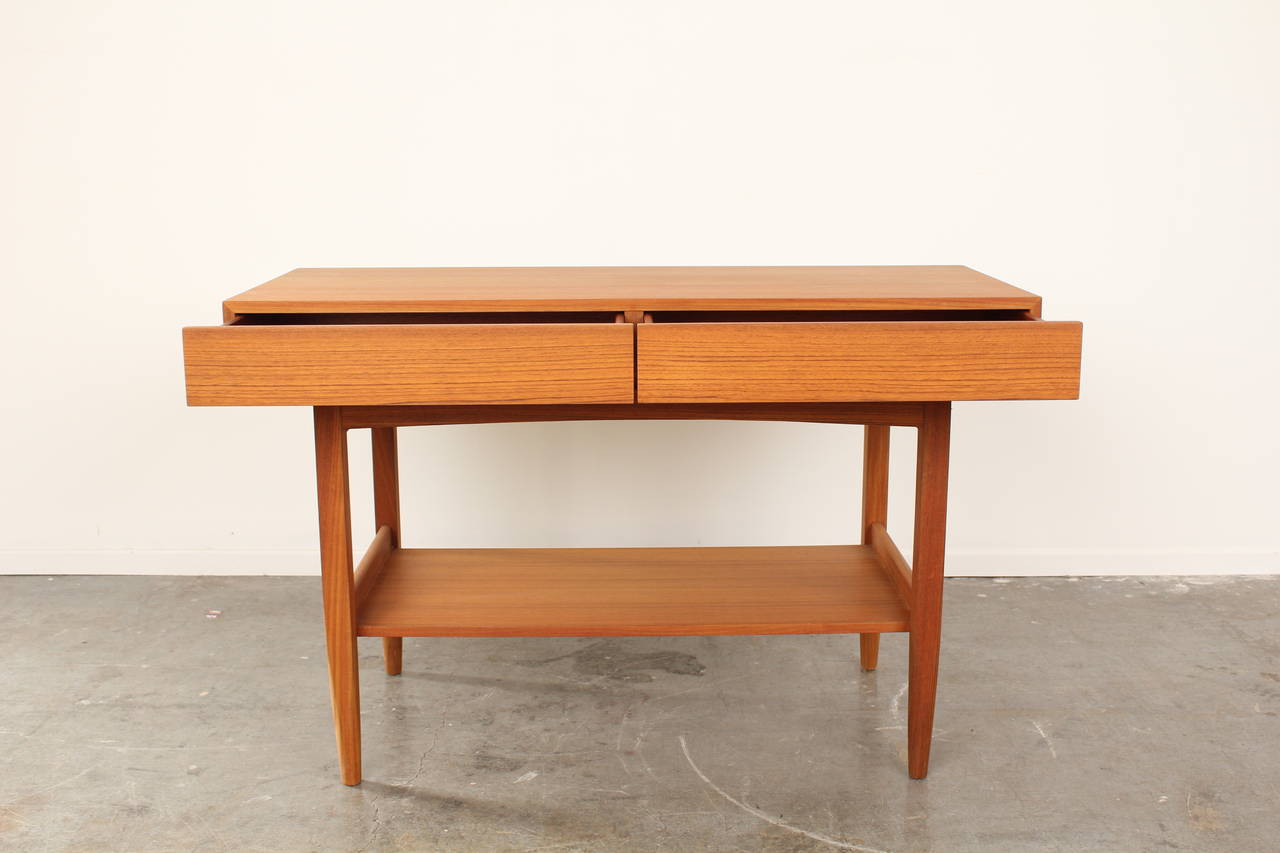 Fantastic mid-century console table by Ib Kofod-Larsen.  Clean lines, bottom shelf, two drawers, and finished back.  Very unique piece and style for the era.