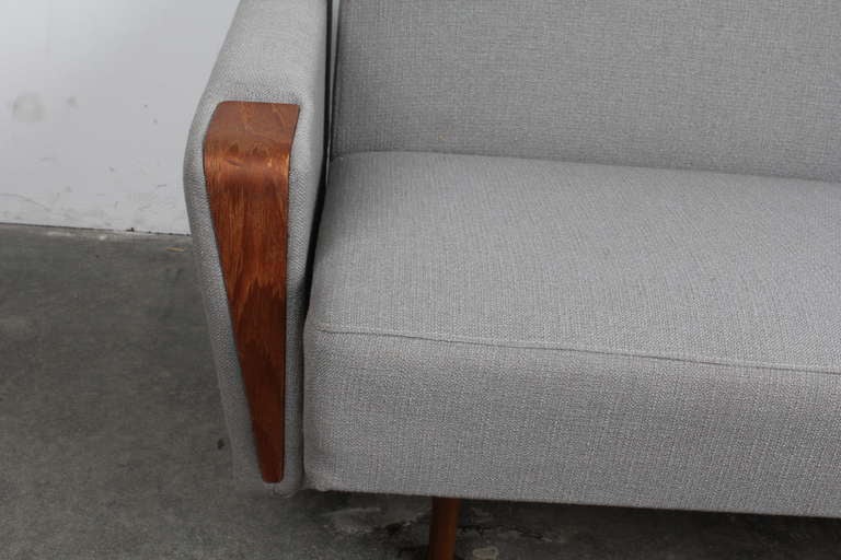 Danish mid century modern tight back 3 person sofa that converts into a sleeper.

Beautiful teak arms and tapering teak legs.