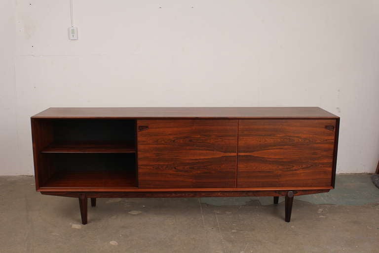 A beautifully designed sideboard in solid and veneered rosewood with special attention to detail particularly in the mitred corners and bevelled leading edges of the cabinet. The louvered handles give the piece a very designed yet still minimal