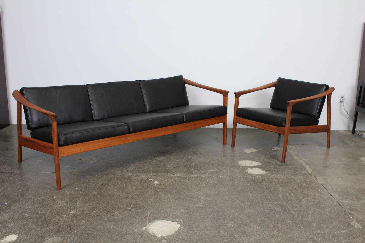 A beautiful and hard to find solid teak lounge chair, designed by Folke Ohlsson - model Colorado, produced by Bodafors in Sweden. Fully refinished with newly upholstered black leather cushions. Exposed back, graceful curves and angles and a low back